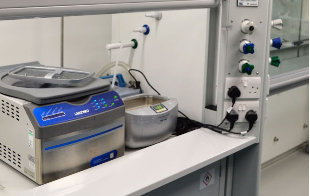 A Fume Cupboard with switches and plugs inside of a laboratory.